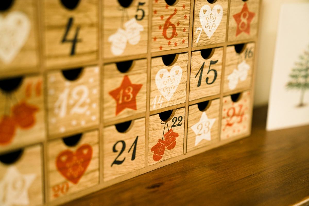 Adventskalender aus Holzschubladen mit aufgemalten Zahlen und Motiven